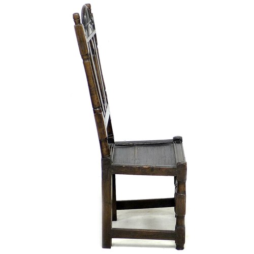 171 - An 18th century oak hall chair, the high back with three splats, below a carved top rail, a solid se... 