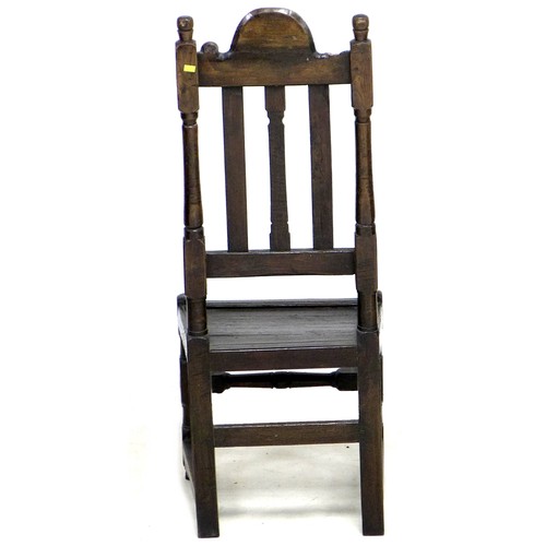 171 - An 18th century oak hall chair, the high back with three splats, below a carved top rail, a solid se... 