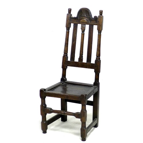 171 - An 18th century oak hall chair, the high back with three splats, below a carved top rail, a solid se... 