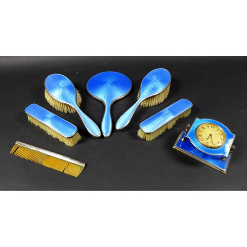 30 - An Art Deco dressing table set, with blue enamel decoration, comprising a hand mirror, two hair brus... 