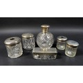A collection of silver lidded cut glass dressing table jars, including a four piece set by Walker & ... 