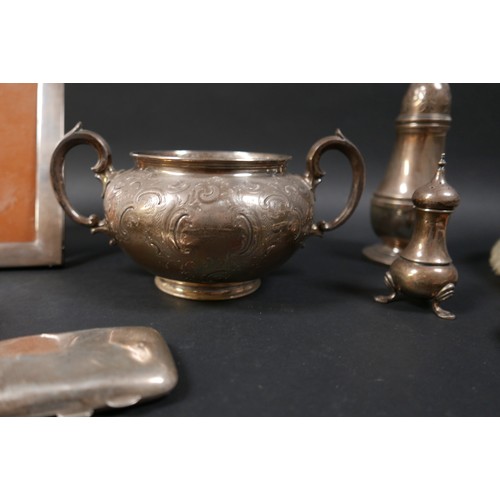 60 - A group of mixed silver items, including a twin handled bowl, sugar caster, pepper, three legged sal... 
