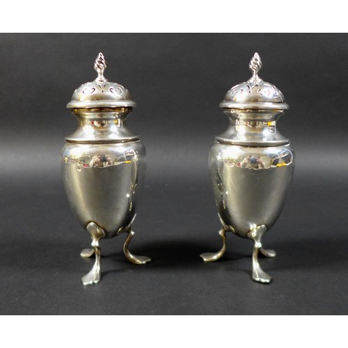 24 - Two Edwardian condiments, both with flame finials, raised upon tripod bases with pad feet, with rubb... 