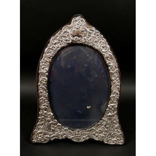 21 - Three ERII silver photograph frames, comprising an oval form frame, decorated with foliate and scrol... 
