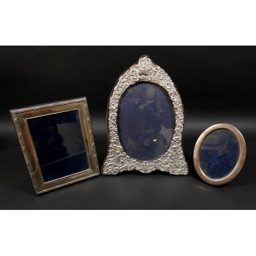 21 - Three ERII silver photograph frames, comprising an oval form frame, decorated with foliate and scrol... 