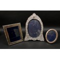 Three ERII silver photograph frames, comprising an oval form frame, decorated with foliate and scrol... 