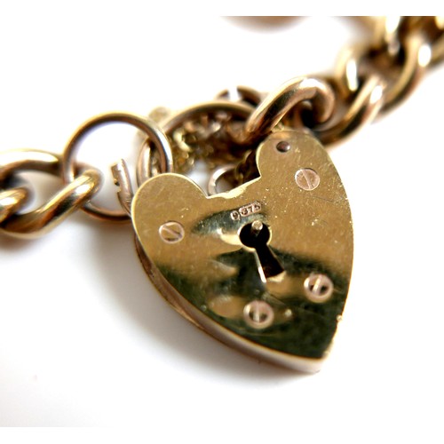 242 - A 9ct gold charm bracelet, with heart shaped padlock clasp, fitted with ten charms, 41.8g.