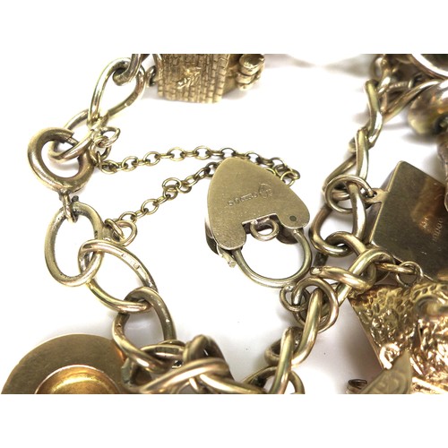 243 - A 9ct gold charm bracelet, with padlock clasp and safety chain, 37.1g overall, chain length 18cm.