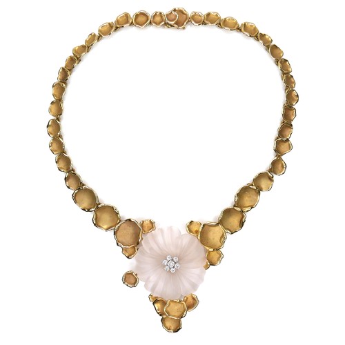 An 18ct yellow gold necklace, in the style of Van Cleef & Arpels, formed as a pale pink frosted glass flower, centered by seven round brilliant cut diamonds, central stone 6mm, and six surrounding stones 1.8mm, held by a garland of organically shaped leaves of graduating size to a press clasp, variously stamped '750', flower head 3.5cm, 36cm long, 63.3g gross.