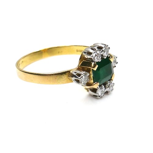 253 - An 18ct gold, emerald and diamond ring, the central Colombian emerald cut stone of of approximately ... 