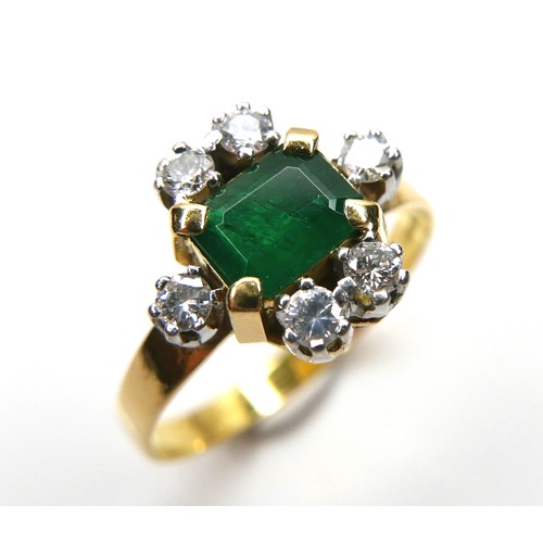 253 - An 18ct gold, emerald and diamond ring, the central Colombian emerald cut stone of of approximately ... 