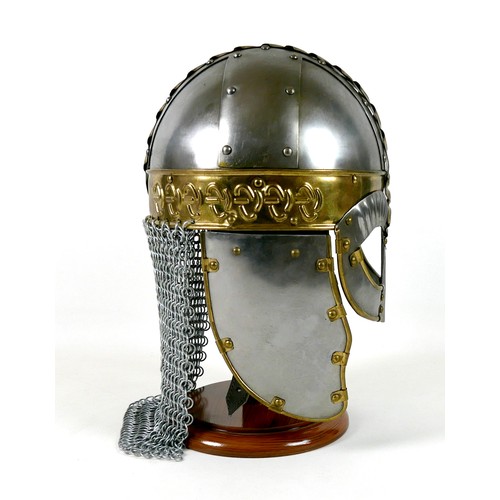 66 - A replica metal steel and brass helmet, with cheek plates, hinged ear flaps, and chain mail neck gua... 