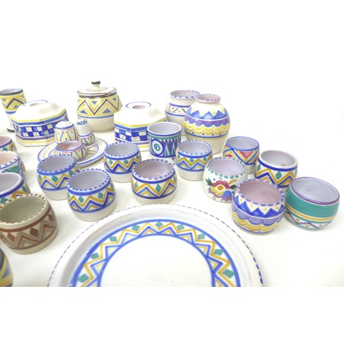36 - A large collection of Poole pottery, including plates, egg cups, candlestick holders and lidded pot.... 