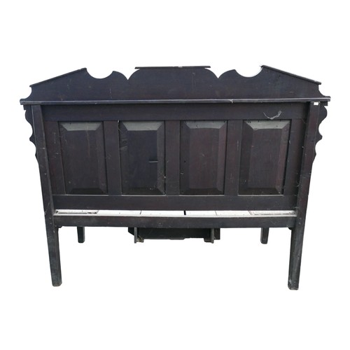 272 - An 18th century oak settle, carved four panel back and removable pediment, open arms, solid plank se... 