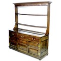 A George III oak dresser, the open plate rack with two shelves below a cornice, the base section wit... 