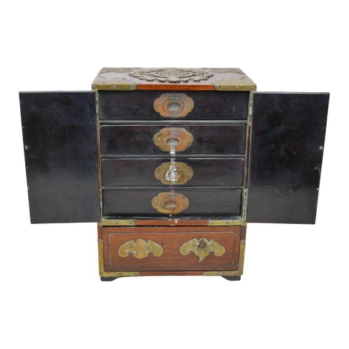 7 - An early 20th century Chinese hardwood table-top cabinet, with four drawers to its interior, lock an... 