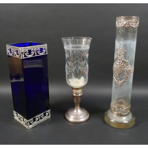 83 - Two silver and white metal mounted glass vases, comprising a blue glass rectangular form vase with p... 