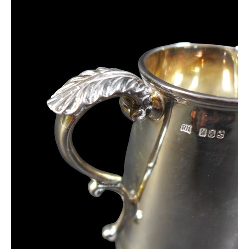 60 - An Irish silver milk jug, of tapering cylindrical form, with foliate thumb rest and double C scroll ... 