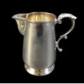 An Irish silver milk jug, of tapering cylindrical form, with foliate thumb rest and double C scroll ... 