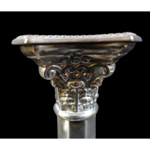 88 - A pair of silver candlesticks, the octagonal section columns with Corinthian capitals and removable ... 