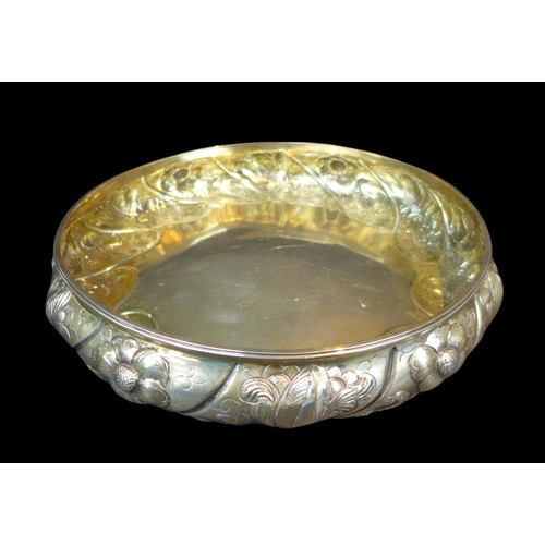 87 - A Victorian silver shallow bowl, of circular form, its sides decorated with repousse flowers and bir... 