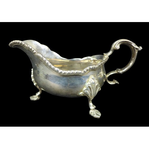 91 - A pair of ERII silver sauce boats, both with scroll handles, scalloped and gadrooned rims, and three... 