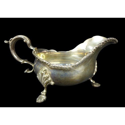 91 - A pair of ERII silver sauce boats, both with scroll handles, scalloped and gadrooned rims, and three... 