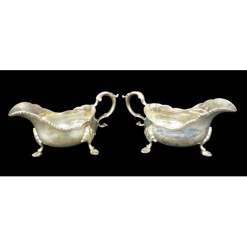 91 - A pair of ERII silver sauce boats, both with scroll handles, scalloped and gadrooned rims, and three... 