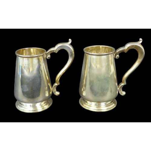 93 - A pair of Elizabeth II silver tankards, each of tapering bellied form with scroll handle, import mar... 