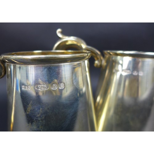 93 - A pair of Elizabeth II silver tankards, each of tapering bellied form with scroll handle, import mar... 