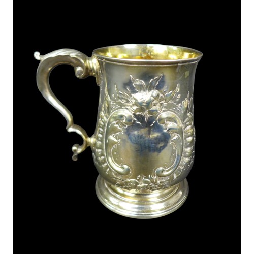 67 - A George III silver tankard, with later repousse decoration, of baluster form with double C scroll h... 