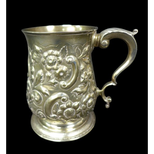 68 - A George III silver tankard, with later repousse decoration, of baluster form with double C scroll h... 