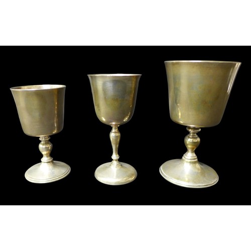 94 - A group of three Elizabeth II silver goblets, each with tapering bowl, knopped stem and circular foo... 