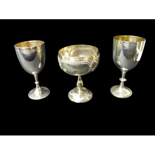 95 - A group of three Victorian and later silver goblets / trophies, comprising one with large bowl embos... 