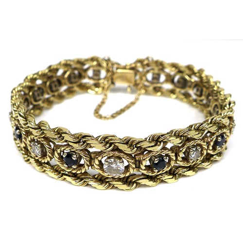 A 14ct gold, sapphire and diamond bracelet, the ornate rope twist design set with ten round cut sapphires and eight brilliant cut diamonds, all of 3.5mm diameter, and two larger brilliant cut diamonds of 4.5mm diameter, 18cm total including clasp, with safety chain, 32.1g.