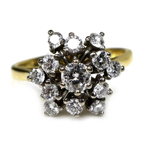 320 - An 18ct gold and diamond starburst cluster ring, set with brilliant cut diamonds, the central larges... 