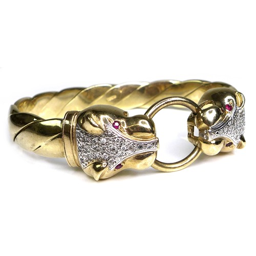 380 - A 9ct gold, diamond and ruby bangle of double leopard's head design, with brilliant cut diamonds set... 