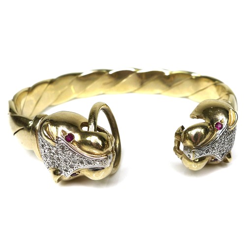 380 - A 9ct gold, diamond and ruby bangle of double leopard's head design, with brilliant cut diamonds set... 