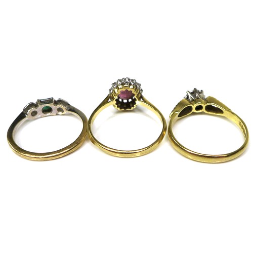 346 - A group of three 18ct gold rings, the first with an emerald and diamond chips set in a platinum face... 