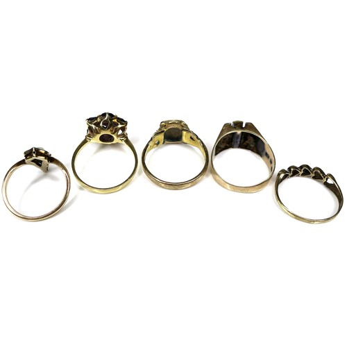 296 - A group of gold rings, comprising an 18ct gold and garnet flowerhead ring, a/f one stone missing, si... 