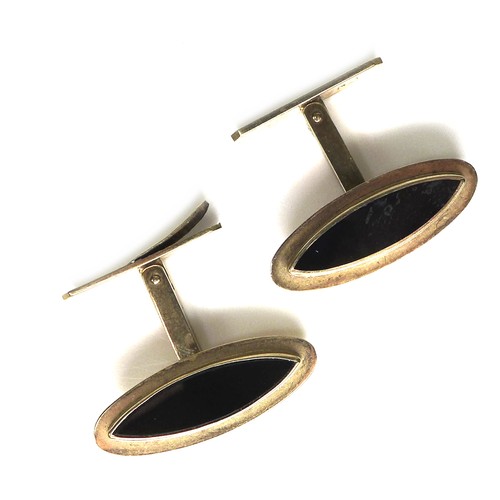 268 - A pair of vintage 9ct gold cufflinks, each of slender navette shape inset with a black stone, 'Swivl... 