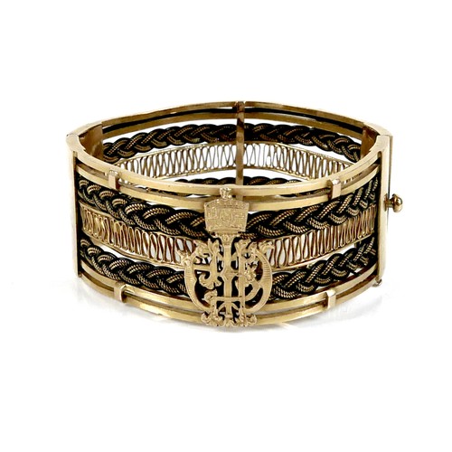 A gold and woven elephant hair cuff bracelet, with the crest of the Emperor of Ethiopia, hinged to one side, press clasp and safety chain, 29mm wide, 2mm thick, 68 by 64mm overall, 80.0g, unmarked but testing as between 18ct and 22ct gold.
Provenance: given as a gift from HIH Princess Medferiash Worq, the daughter-in-law of the Ethiopian Emperor Haile Selassie I in the mid 1980s, with letter sent from The Palace of HIH the Crown Prince, 11th July 1964, thanking Mrs Hancock for hosting their daughters Mary and Sihin on their first holiday in England, a hand written note (on the back of a Buckingham Palace entry note to the Royal Mews dated 1982) describing this bracelet and gifting it to Sarah, and a scrap of Country Life highlighting a similar bracelet sold at a Bonham's charity sale in 2002 for £1300.
Note: similar bracelet in the collection held by the John F. Kennedy Presidential Library and Museum, Boston MA, given to First Lady Jacqueline Kennedy by Haile Selassie in 1963.