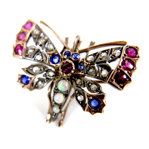 312 - An unmarked gold brooch, formed as a butterfly, early 20th century, its wings set with white, red an... 