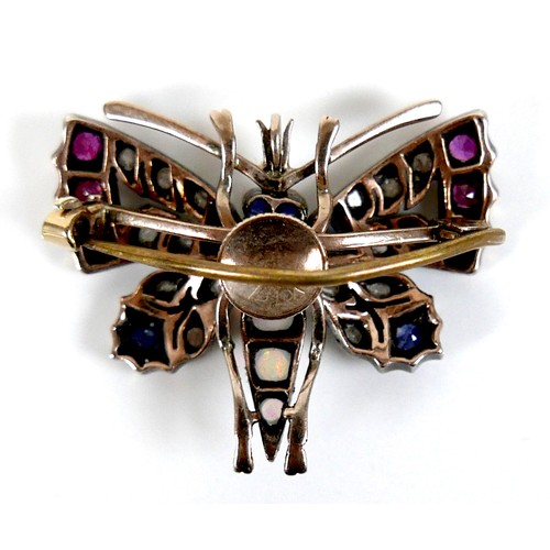 312 - An unmarked gold brooch, formed as a butterfly, early 20th century, its wings set with white, red an... 