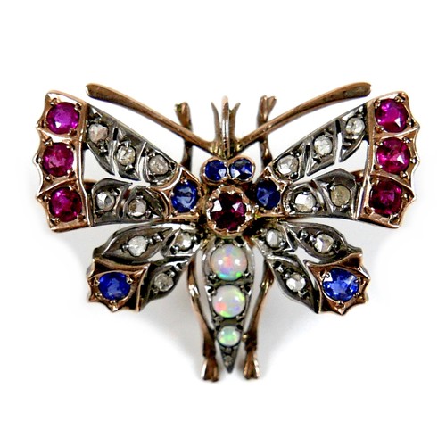 312 - An unmarked gold brooch, formed as a butterfly, early 20th century, its wings set with white, red an... 