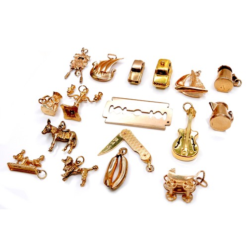 378 - A group of seventeen 9ct yellow gold charms, comprising folding pen knife, candelabra, razor blade, ... 