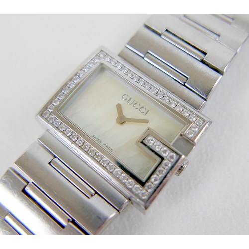 247 - A Gucci stainless steel lady's wristwatch, with diamond set G-shaped bezel, model 100L, serial 10344... 