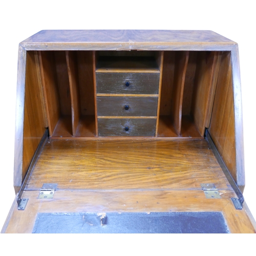 251 - An Art Deco walnut veneered student's desk, with fall front enclosing writing skivver and fitted int... 