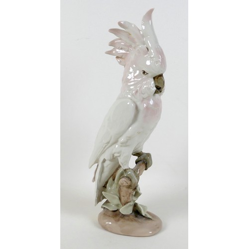36 - A Royal Dux porcelain figurine, modelled as a cockatoo standing on a branch, with pink plumage, with... 