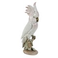 A Royal Dux porcelain figurine, modelled as a cockatoo standing on a branch, with pink plumage, with... 